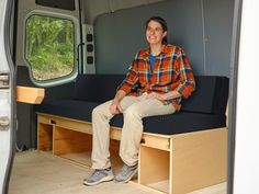 a man sitting in the back of a camper van with his feet propped up