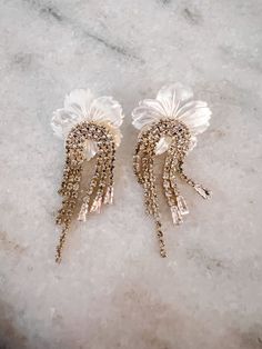 Make an elegant statement with the Gatsby Peony Drops! Balanced and beautiful mix of mother of Pearl flower and different size crystals that create the tassel look! Glamorous Spring Wedding Jewelry, Elegant Spring Jewelry With Rhinestones, Elegant Flower Embellished Jewelry, Elegant Embellished Flower Jewelry, Elegant Embellished White Earrings, Elegant White Embellished Earrings, Pearl Flower, Gatsby, Mother Of Pearl