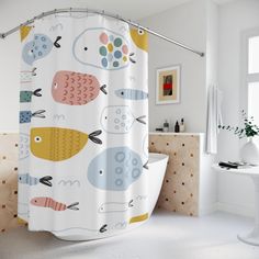 a bathroom with a shower curtain that has fish on it, and an animal print