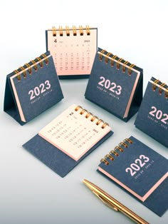 three calendars with the numbers on them and a pen sitting next to one another