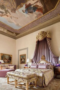 a bedroom with a large bed and paintings on the ceiling