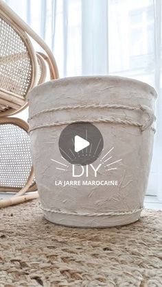 a white bucket sitting on top of a rug next to wicker chairs and windows