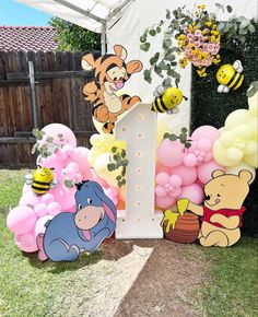 winnie the pooh birthday party decorations with balloons and honeybees on display outside