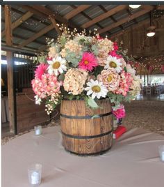 a wooden barrel filled with flowers on top of a table