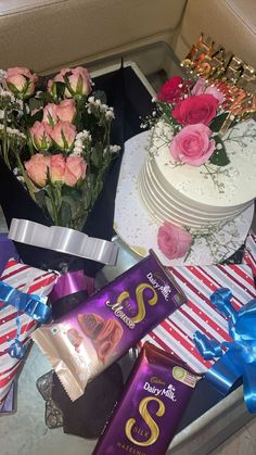 a table topped with cake, flowers and chocolates