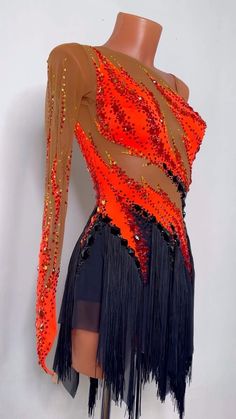 an orange and black dress with sequins on the top, fringed skirt