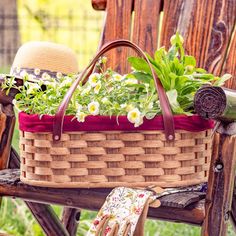 a basket filled with flowers sitting on top of a wooden chair