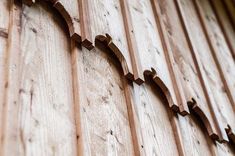 a wooden wall with some wood carvings on it's side and one is missing