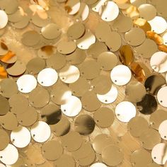 gold and white sequins are arranged on a table