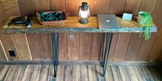 a laptop computer sitting on top of a wooden table next to a lamp and other items