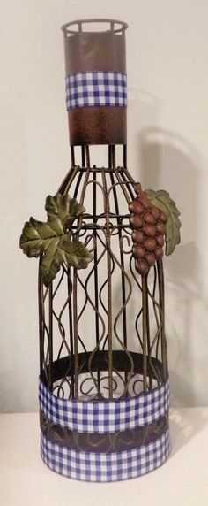 a decorative birdcage with grapes and leaves on it