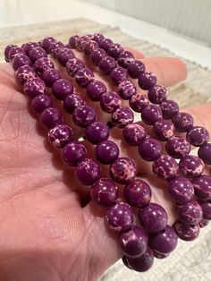 Stabilize & Shine Daily! Embrace the calming power of the ocean with our Purple Emperor Bracelets. Crafted from Sea Sediment Jasper, also known as Ocean Jasper, this stretch bracelet features 6mm beads and has a 3-inch diameter, perfect for daily wear or meditation. Known for its stabilizing qualities, Sea Sediment Jasper shields against negativity and alleviates emotional stress. Adorn yourself with this gemstone to carry its soothing energy with you wherever you go. Spiritual Stretch Bracelet With Hypoallergenic Round Beads, Hypoallergenic Stretch Bracelet For Meditation, Meditation Stretch Bracelet With Round Beads, Flexible Spiritual Beaded Bracelet With Round Beads, Purple Gemstone Beaded Bracelets For Meditation, Purple Faceted Amethyst Bracelets, Purple Emperor, Purple Jasper, Purple Faceted Beads Amethyst Gemstones