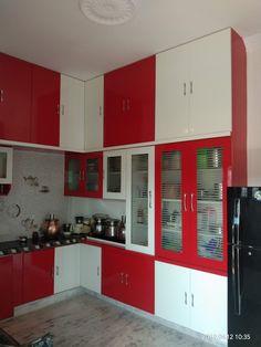 a kitchen with red and white cupboards and appliances