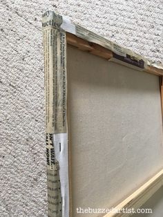 an old photo frame is being taped to the wall with tape and some other pieces of paper