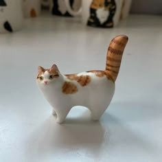 a white and brown cat figurine sitting on top of a table