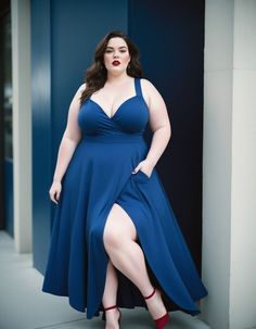 a woman in a blue dress posing for the camera with her legs crossed and one leg bent