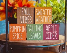 wooden blocks that say fall vibes weather, pumpkin falling apple cider and spice leaves cider