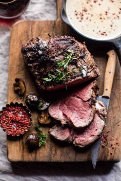 roast beef on a cutting board with mushrooms and herbs