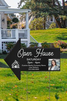 an open house sign in front of a lawn with flowers on the grass and trees