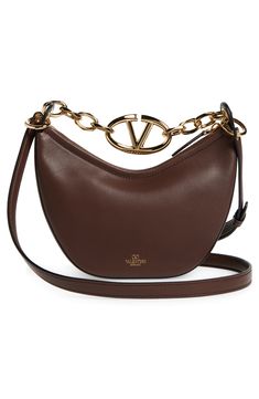 A gleaming chain centered with a VLOGO insignia spans the top of this hobo crafted from grained leather in a slouchy crescent silhouette. Top zip closure Chain top carry handle; removable, adjustable shoulder strap Leather Made in Italy Designer Handbags Elegant Brown Shoulder Bag With Metal Logo, Luxury Brown Shoulder Bag With Metal Logo, Brown Shoulder Bag With Metal Logo For Everyday, Luxury Brown Bag With Metal Logo, Chic Brown Bags With Metal Logo, Chain Top, Hobo Bag, Valentino Garavani, Crescent