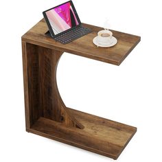 a laptop computer sitting on top of a wooden desk next to a cup of coffee