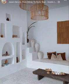 a living room filled with lots of white furniture and decor on top of it's walls