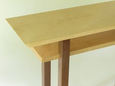 a small wooden table with two legs on it's sides and one end missing