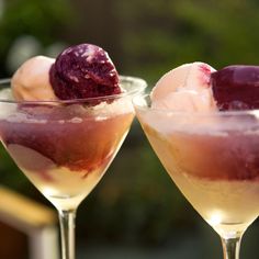 two glasses filled with ice cream and raspberries