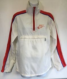 Here's a classic vintage Nike windbreaker! A large Nike logo is printed on back. The red, white, and blue color combo is perfect! There is a Nike tag inside the large front zipper pocket with the added bonus of being able to stuff the whole jacket into the pocket, zip it up, and peace out with your pouch! It shows some general wear---small marks, a hole at the pit seam, graphic wear, etc. But overall the fabric is in good condition and it has tons of fun left in it! Check out other sensational v Retro Spring Windbreaker For Outdoor, Vintage Windbreaker For Fall Sports, Retro Red Track Jacket For Outdoor, Retro Track Jacket For Spring Streetwear, Retro Spring Track Jacket For Streetwear, Red Retro Track Jacket For Outdoor, Retro Hooded Track Jacket For Sports, Retro White Windbreaker For Spring, Vintage Red Track Jacket For Outdoor