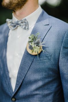 a man in a blue suit with a boutonniere on his lapel