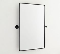 a mirror mounted to the side of a wall next to a black faucet