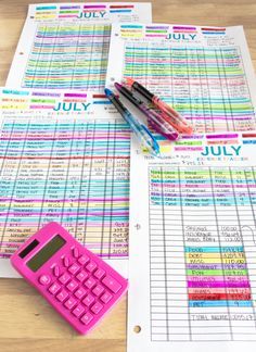 a pink calculator sitting on top of a table next to a pile of papers