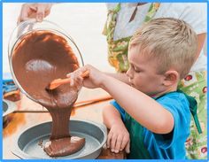 a little boy that is standing in front of a pan