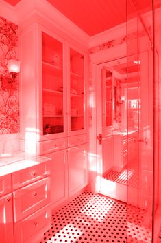 a bathroom with black and white flooring and red light coming in from the window