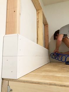 a man is working on some kind of thing in the room that's being built