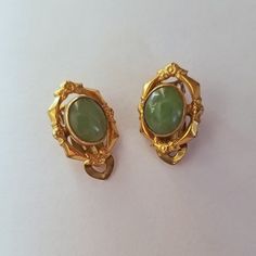 This is a pair of vintage estate jade earrings made in the 60's in their original box. They are genuine with ornate 12K gold filled oval frames. Art Deco Oval Earrings For Formal Occasions, Oval Art Deco Earrings For Formal Occasions, Formal Oval Art Deco Earrings, Victorian Gold Cabochon Earrings, Gold Victorian Cabochon Earrings, Antique Brass Oval Earrings, Antique Oval Brass Earrings, Vintage Green Cabochon Earrings, Vintage Yellow Gold Collectible Earrings