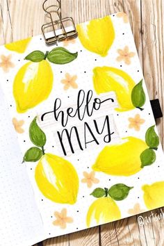 a clipboard with the words hello may written on it and lemons around it