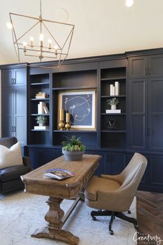 a living room filled with furniture and a chandelier hanging from the ceiling over a wooden table