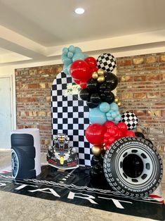 the balloon arch is decorated with black, white and red balloons that are shaped like a race car