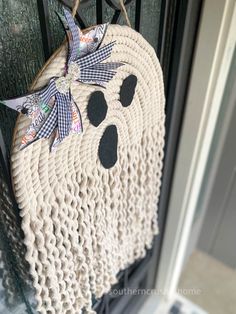 a woven bear decoration hanging on the front door