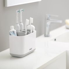 the toothbrush holder is filled with many different types of toothbrushes in it