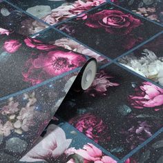 a roll of black and pink floral wallpaper next to a white flowered floor