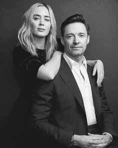 a man and woman are posing for a black and white photo with their arms around each other