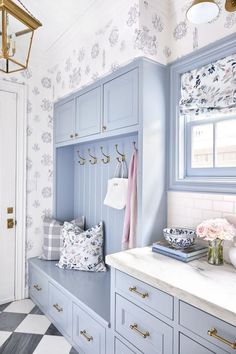 a bathroom with blue cabinets and white counter tops in front of a checkered floor