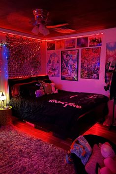 a bedroom with pink lights and posters on the wall