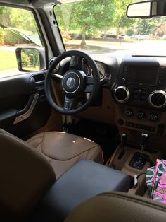 the interior of a vehicle with steering wheel and dash board, leather seats and dashboard