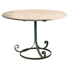 a round table with an iron base and marble top