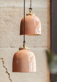 two light fixtures hanging from a brick wall