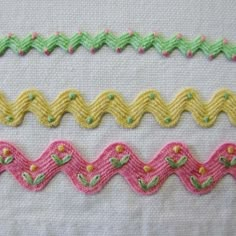 three different types of stitching on white fabric with pink, green and yellow trims