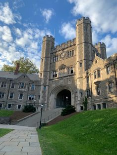 a large castle like building with a clock on it's face and stairs leading up to the entrance